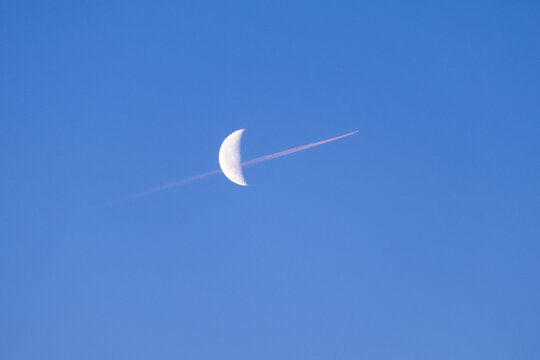 Moon and airplane on morning sky.