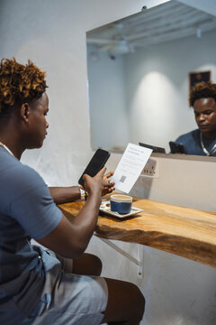 Man Scanning QR Code in Caf&eacute;