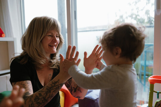 Woman And Toddler Playing Hand Game At Home