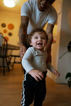 Toddler taking first steps with help