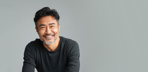 Portrait Headshot of a Middle Age Asian Man on a Light Grey Background with Space for Copy