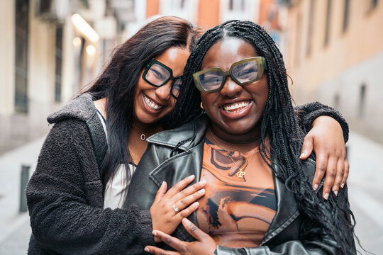 Two friendly women laughing together on the street