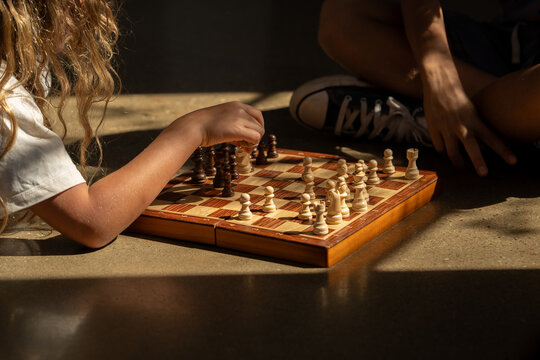 A chess board on the floor with a golden light perking through.