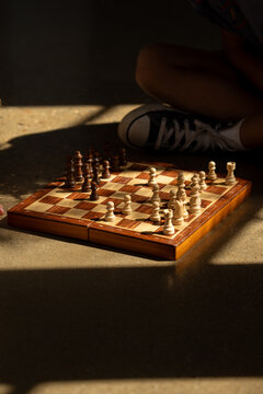 A chess board on the floor with a golden light perking through.