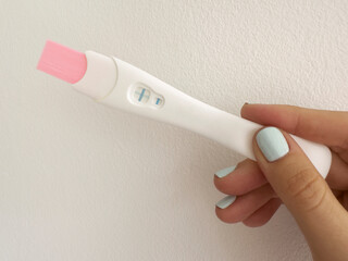 Positive pregnancy test in hand closeup