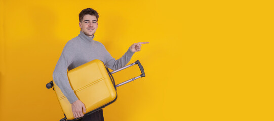 isolated young man or student with suitcase pointing