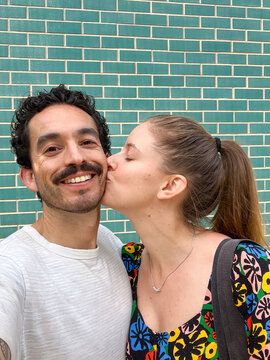 Selfie of a happy couple while the girlfriend kisses her boyfriend