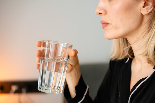 A woman drinks water in the morning