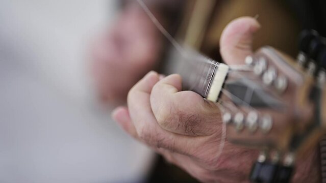 Man play bouzouki folk music traditional instrument in slow motion on street in Athens, Greece