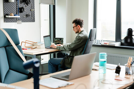 A man uses a laptop in the office