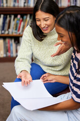 Women, tutor and university library with books or study help or education learning, teamwork or...