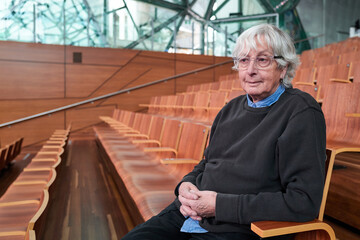 Senior transgender woman sitting in theatre