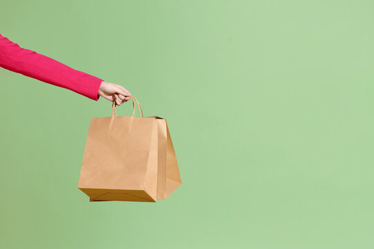 Recycled paper shopping bags on green background