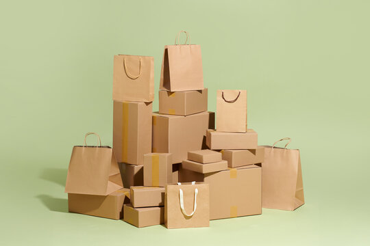 Kraft packaging, boxes, and packages on a green background. Delivery.
