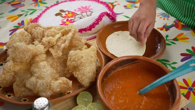 Mexican woman preparing a chicharron taco
