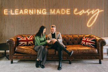 Professionals reviewing content on a tablet in e-learning space