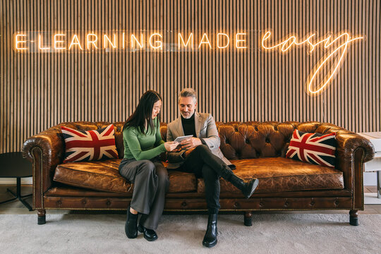 Professionals reviewing content on a tablet in e-learning space