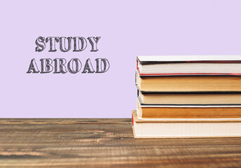 A stack of books with the word study abroad written on top