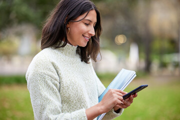 Fototapeta premium Student, phone text and woman portrait in a park with learning, research and info on campus. Smile, mobile and university women with notes, social media and college test with a study break outdoor