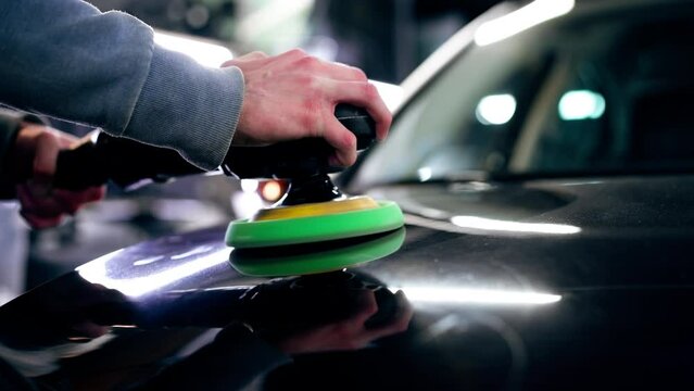 close-up of the hands of a car mechanic at a service station doing the final polishing to shine