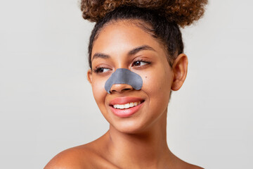 A woman with a black nose patch smiles