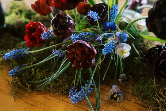 spring season floral design on dining table with tulip, muscari candle