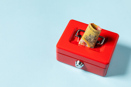 An Australian fifty dollar bill inside a red savings box