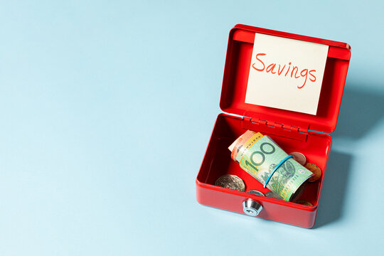 A 100 Australian dollar bill rolled inside a red box