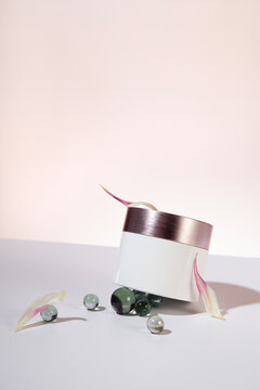 Cream package on a light background arranged with floral decoration