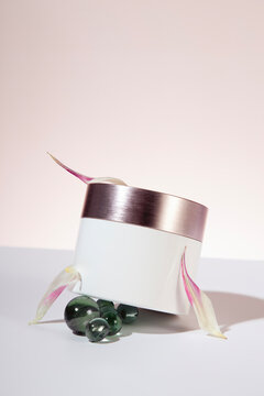 Cream package on a light background arranged with floral decoration