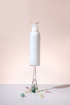 Cosmetic product on a light background arranged with floral decoration