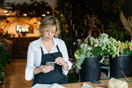 Florist checking phone at flower shop