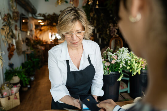 Florist processing payment in flower shop