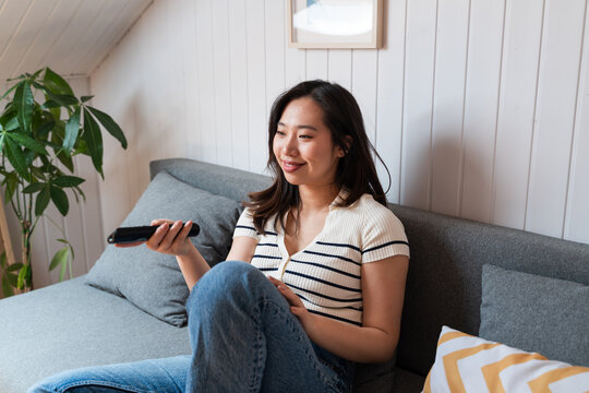 Woman relaxing with tv remote at home