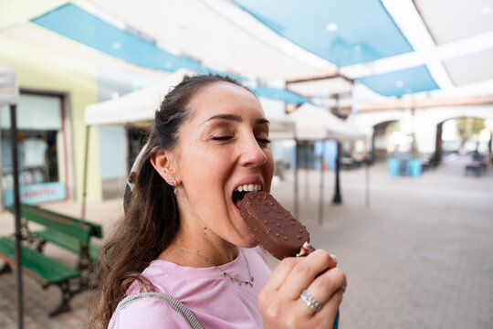 Woman enjoying chocolate ice cream outdoors