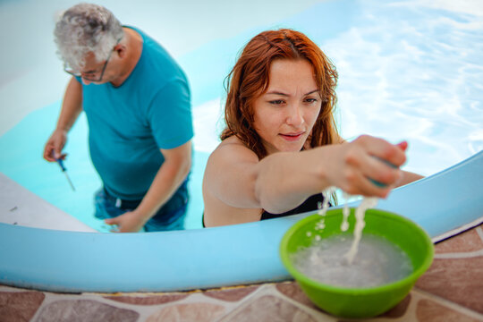 Father and daughter washing a pool