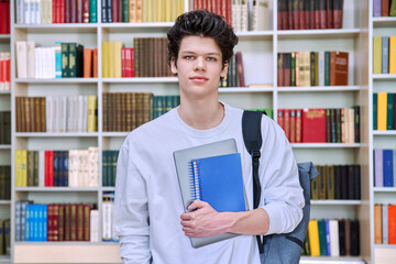 Portrait of college student teenage male inside library of educational building