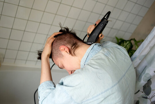 Woman cuts her head with a clipper
