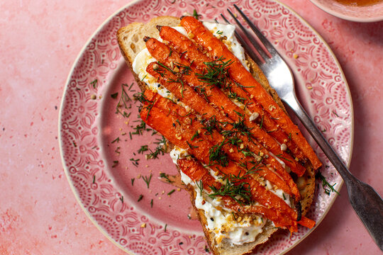 Carrots on toast on pink background