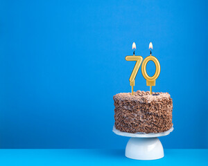 Birthday celebration with candle 70 - Chocolate cake on blue background