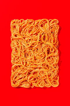 Rectangular composition of spaghetti on red background