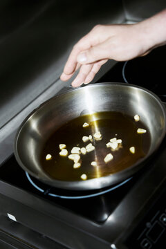 Adding garlic to a pan with oil 