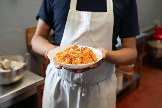Anonymous Cook Holding Carrot Halwa On The Plate