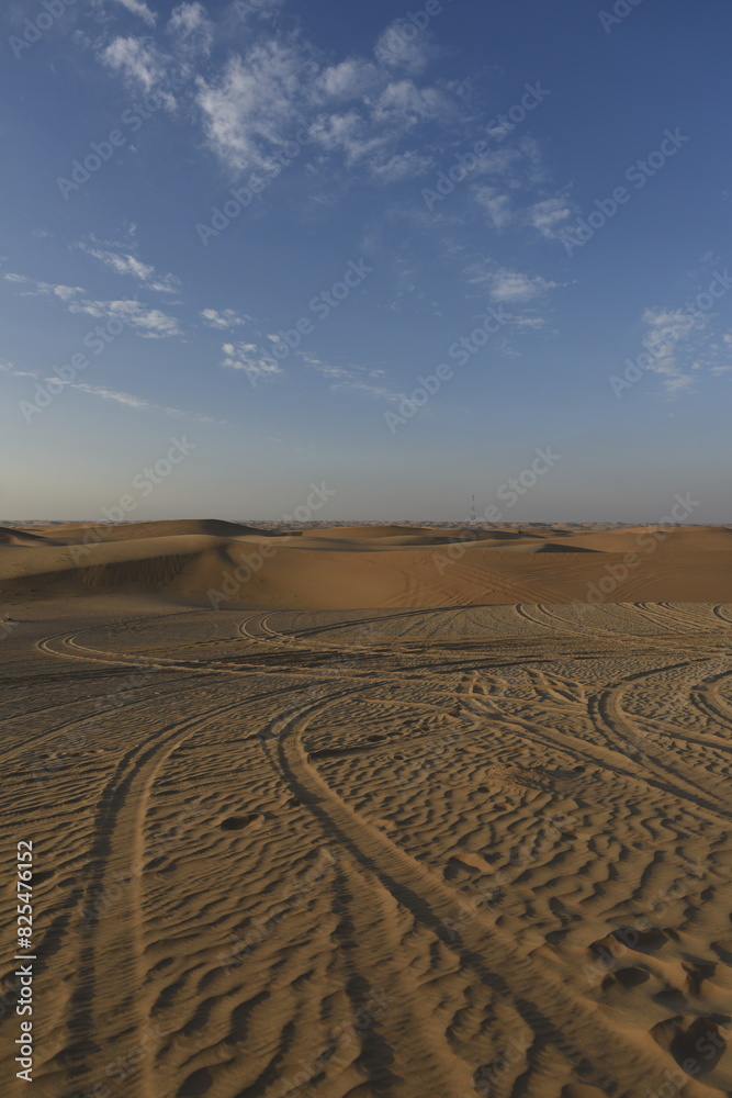 Sticker Scenic view of sandy dunes in a desert at sunset