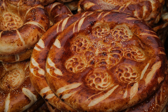 Traditional Central Asian Bread Displayed on Ornate Fabric at a Local 