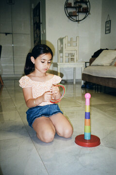 Child Focused On Ring Stacking Toy, Moment Of Concentration And Joy.
