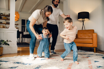 happy family with young child and baby having a dance party