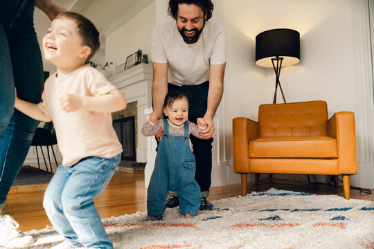 happy family with young child and baby having a dance party