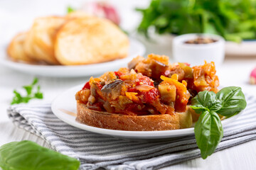 Stewed vegetables on a slice of bread.