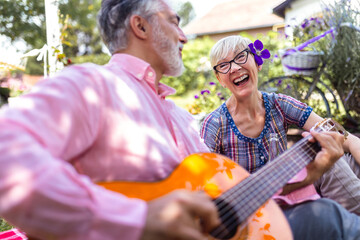Music, guitar and a senior couple on picnic in park, romance in retirement.